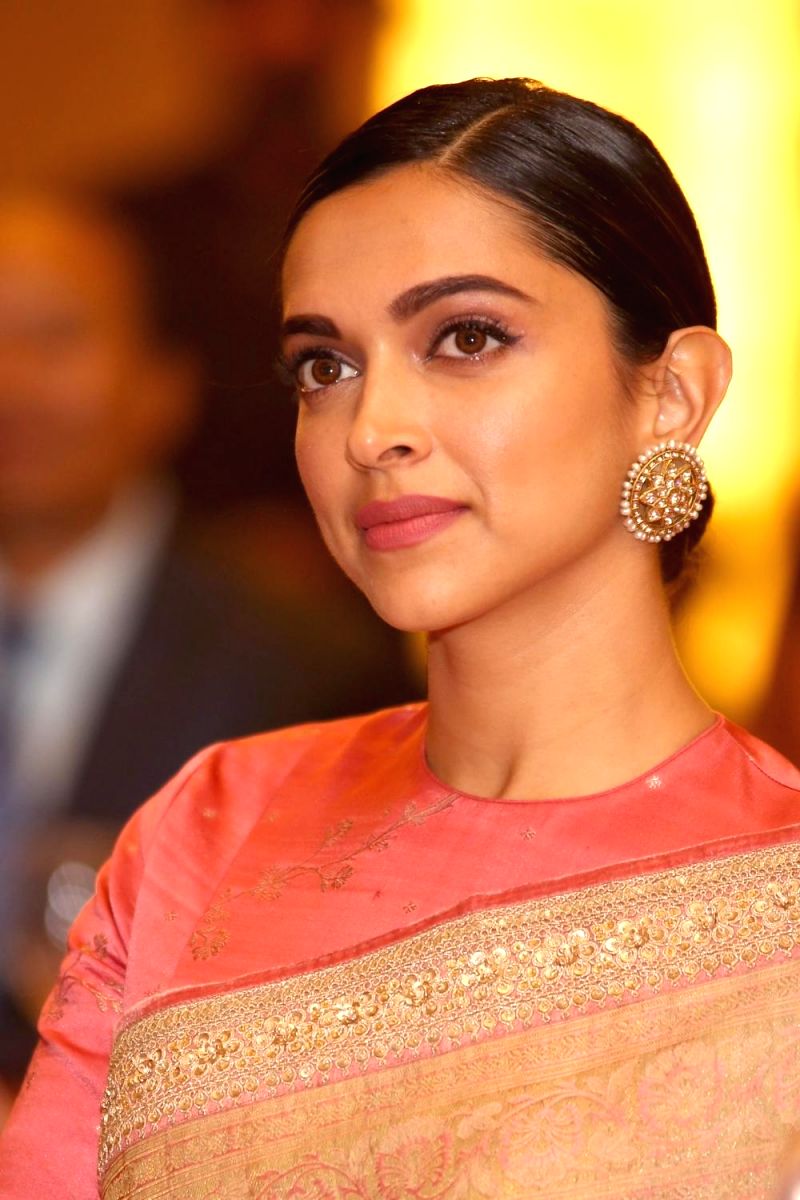 Deepika looks sophisticated in this lovely salmon colored saree, complete with a pair of traditional stud earrings