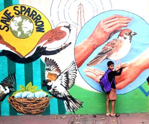 Mumbai : Children Walk Past A Painted Wall Featuring The Theme Of Sparrow