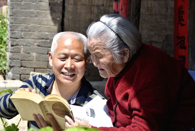 SANMENXIA, April 23, 2017 - The 95-year-old Wei Zuhe (R) and his 59-year-old son read a book in Qianqiu Village of Yima City, central China's Henan Province, April 23, 2017. The World Book Day falls ...